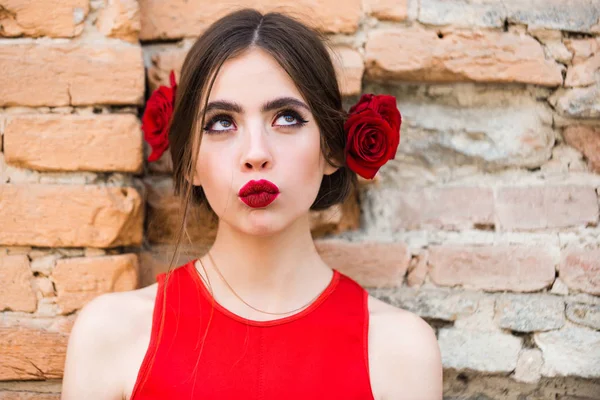Fashionabla kvinna i ljusa röd klänning med ros i håret — Stockfoto