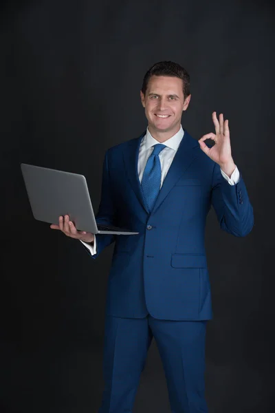 El hombre que trabaja en el ordenador portátil y haciendo buen gesto — Foto de Stock