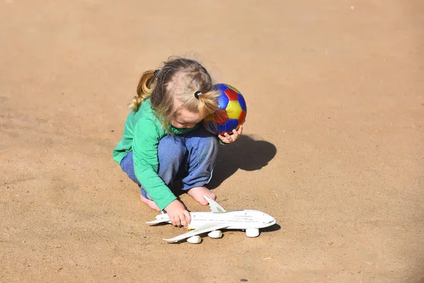 Dziecko bawi się samolot zabawka i piłka — Zdjęcie stockowe
