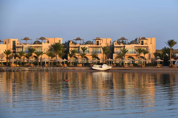 Hotel met groene palmbomen en witte boot op natuurlijke achtergrond — Stockfoto