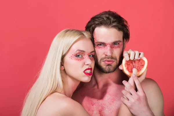 Пара женщина и мужчина с макияжем держать грейпфрут — стоковое фото
