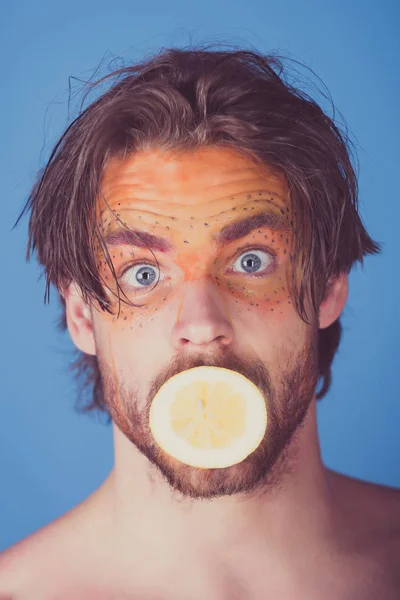 Guapo sorprendido hombre con creativo maquillaje de moda mantenga limón, vitamina — Foto de Stock