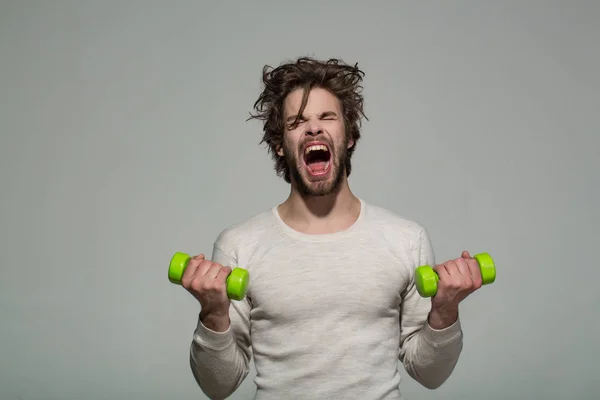 Sleepy man with barbell doing morning exercise, has uncombed hair — Stock Photo, Image
