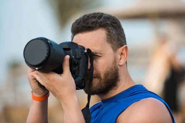 Man professional photographer holding his black digital camera — Stock Photo, Image