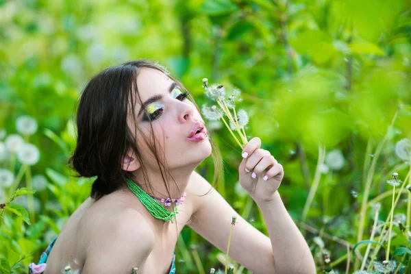 Девушка с модным макияжем и бусами в зеленых листьях — стоковое фото