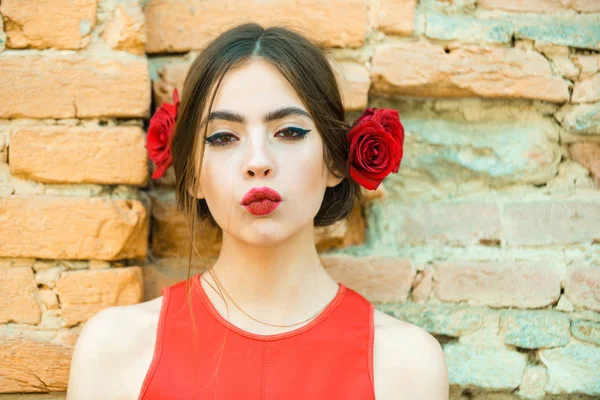 Mujer con labios rojos y rosas frescas en el cabello —  Fotos de Stock
