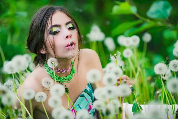 Flicka med trendiga smink och pärlor i gröna blad — Stockfoto
