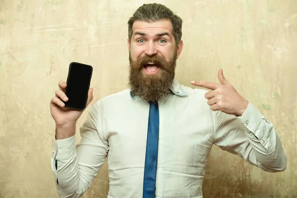 Hipster of bebaarde man met lange baard houd telefoon — Stockfoto