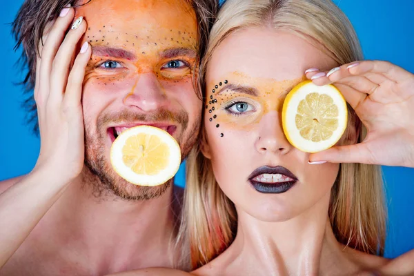 woman and happy man with makeup hold lemon