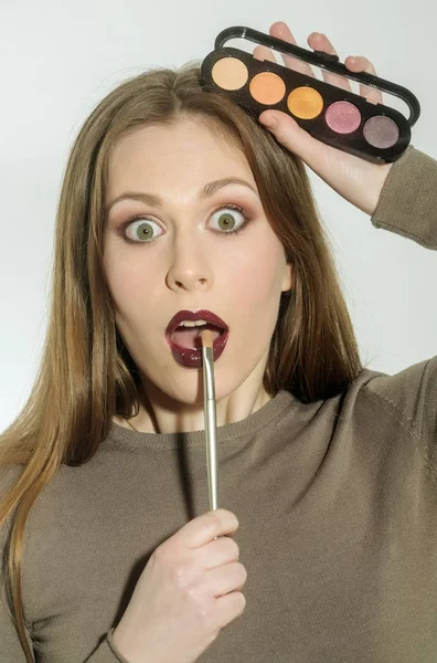 Menina aplicando maquiagem no rosto bonito com escova — Fotografia de Stock