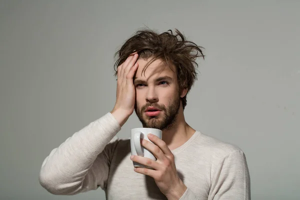 Sonnolenza uomo stanco con mal di testa tenere una tazza di tè — Foto Stock