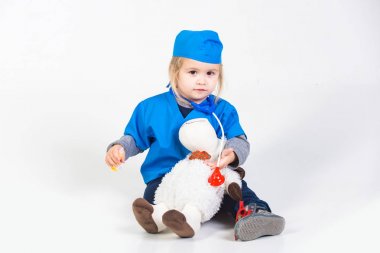 Doktor veteriner oyuncak hayvan ile oynarken üniforma içinde küçük çocuk