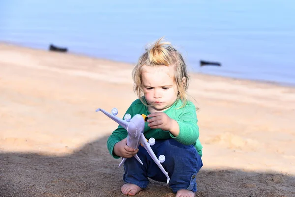 Chłopiec dziecko grając z samolocikiem, w pobliżu plaży i ocean — Zdjęcie stockowe