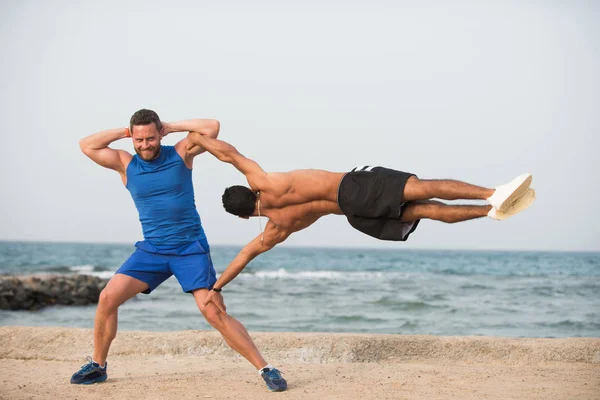 Sportler zwei junge hübsche lächelnde Jungen trainieren akrobatischen Trick Teamwork — Stockfoto