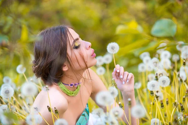 Maskros fält och vackra flicka med trendiga smink — Stockfoto
