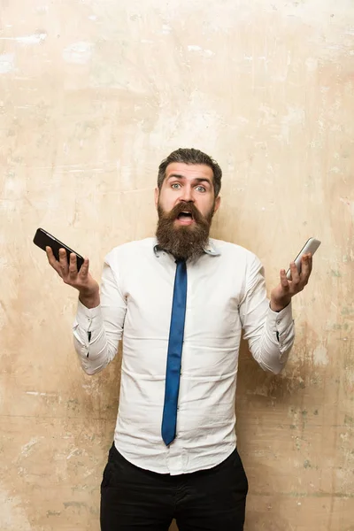 Hombre de negocios o barbudo comparar teléfono móvil y teléfono inteligente —  Fotos de Stock