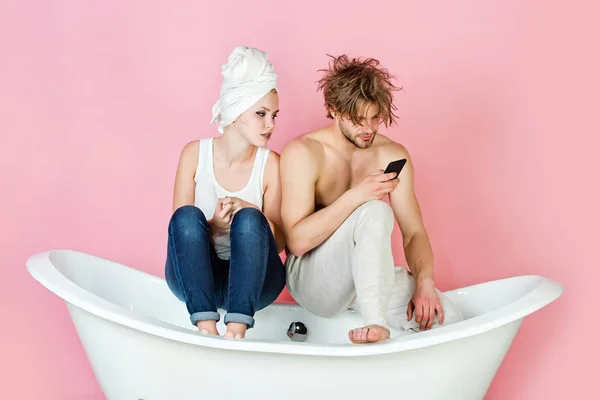 Pár v lásce, muž a žena na vanu s telefonem — Stock fotografie