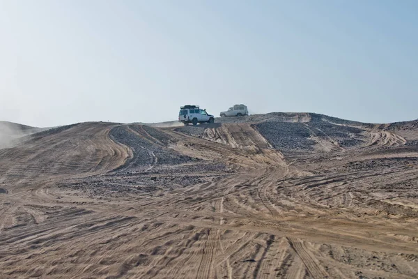 Trilhas de rodas em dunas de areia e carros dirigindo no deserto — Fotografia de Stock