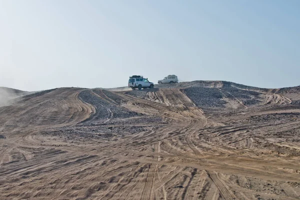 Piste su ruote su dune di sabbia e auto che guidano nel deserto — Foto Stock