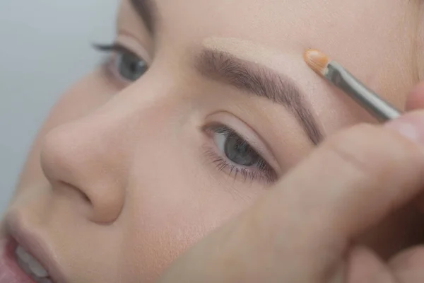 Girl getting foundation cream on face with brush — Stock Photo, Image