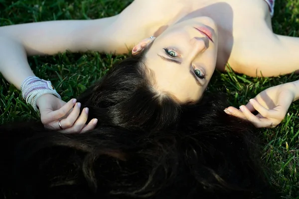 Menina bonita ou mulher bonita deitada na grama verde — Fotografia de Stock