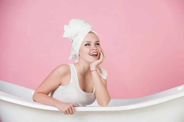 Happy sexy woman with towel turban sitting in white bathtub — Stock Photo, Image