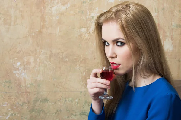 Girl drinking red liqueur in glass
