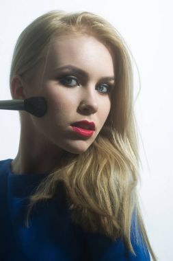 Kırmızı dudaklar toz yüz fırça ile uygulayarak kadınla