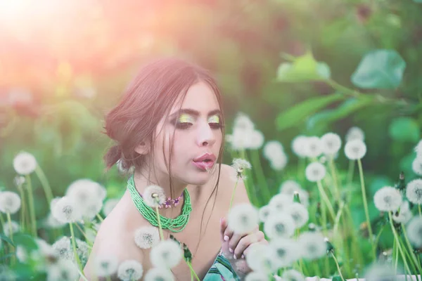Девушка с модным макияжем и бусами в зеленых листьях — стоковое фото