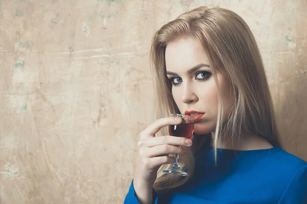 Mulher bebendo licor vermelho em vidro — Fotografia de Stock