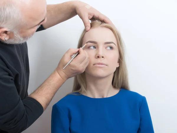 Visagiste aplicando maquillaje en la cara de chica — Foto de Stock