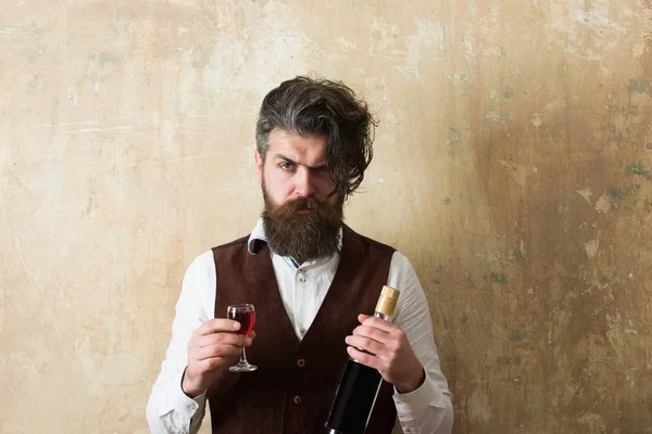 Homem segurando garrafa e copo de vinho — Fotografia de Stock