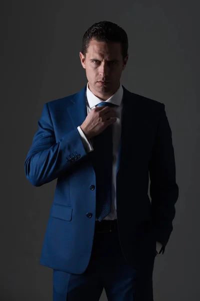 Erfolgreicher Mann, der Krawatte im eleganten blauen formalen Anzug anpasst — Stockfoto