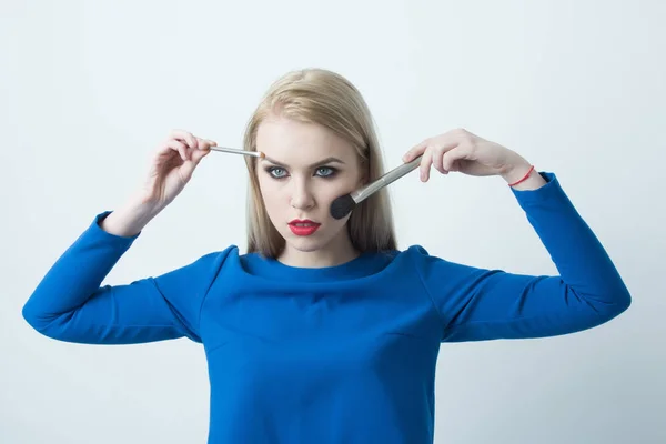 Mujer con pinceles de maquillaje en la cara aplicando polvo y sombra —  Fotos de Stock