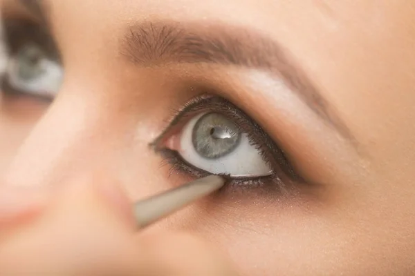 Olhos de menina recebendo maquiagem contorno com sombra preta — Fotografia de Stock