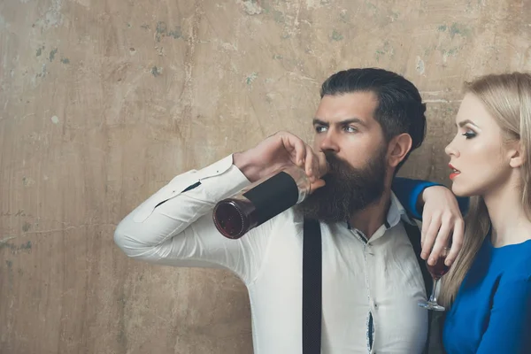 Vrouw met glas op zoek naar man drinken wijn uit de fles — Stockfoto