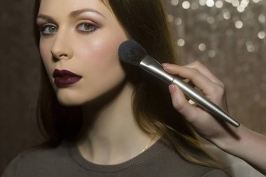 Profesyonel makyöz güzel genç bir kadınla çalışıyor.