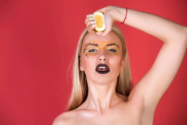 girl with creative fashionable makeup hold lemon, vitamin