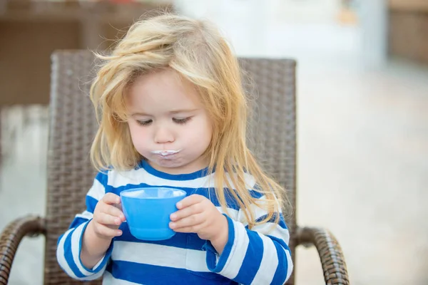 Schattige kleine jongen met melk snor kopje melk drinken — Stockfoto