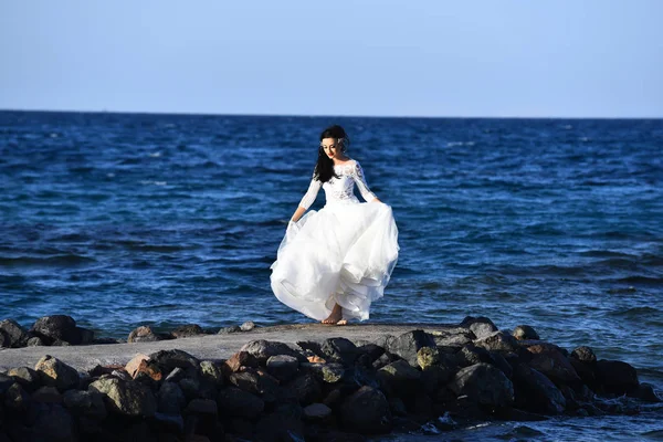 Bride beautiful woman walking along beach