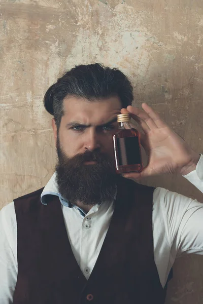 Hipster posiert mit Flasche roten Likör — Stockfoto