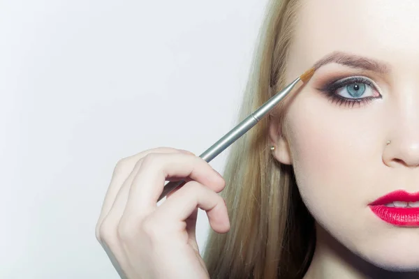 Mujer que aplica sombra de ojos en el ojo con cepillo de maquillaje — Foto de Stock