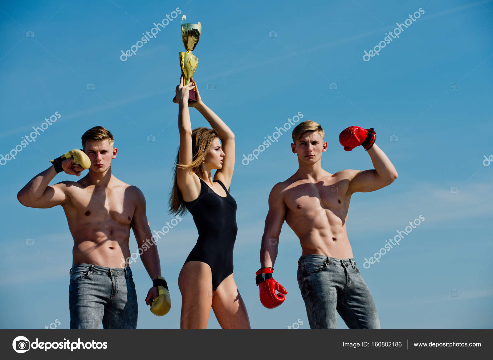 Woman and twins with muscular body hold champion cup. Stock Photo