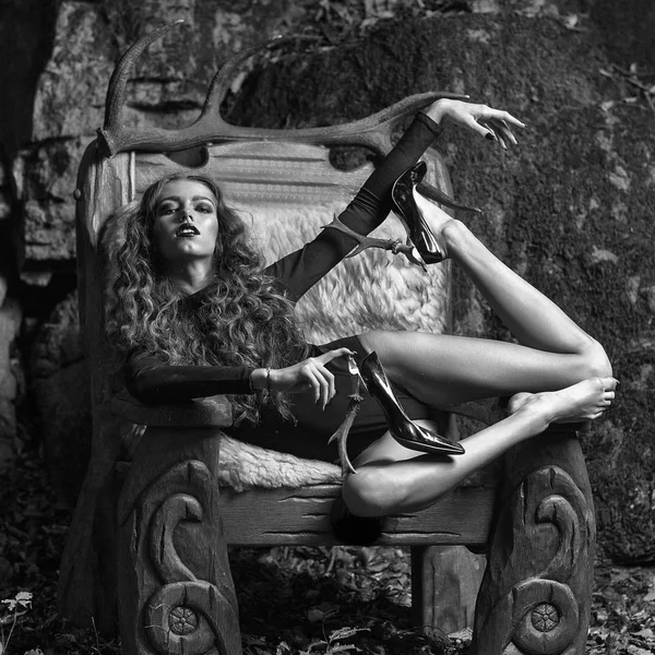 森林での毛皮でビッグアーム木製椅子の少女 — ストック写真