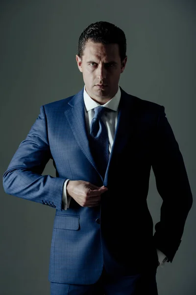 business fashion, businessman buttoning button on elegant blue formal suit