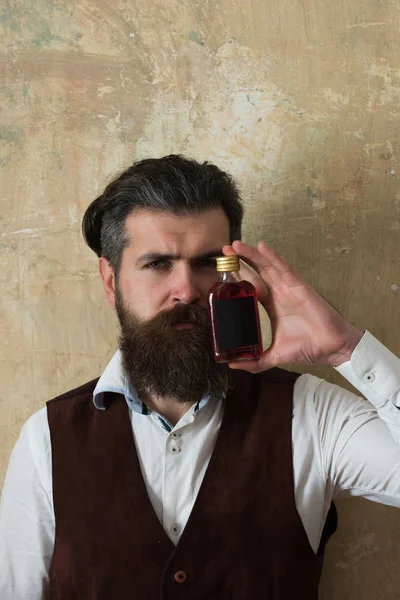 Homem posando com garrafa de licor vermelho — Fotografia de Stock