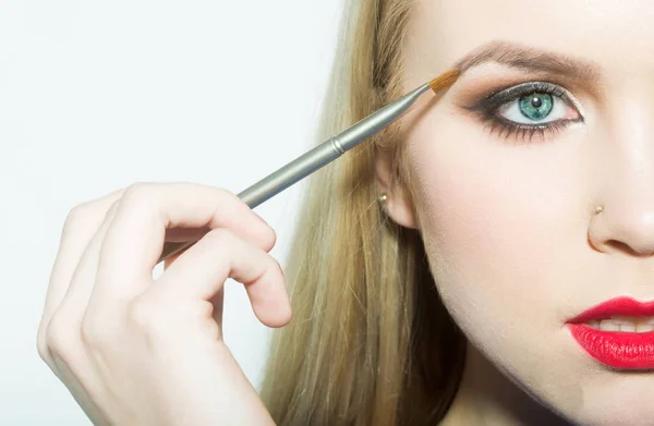 Girl half face drawing eyebrow with makeup brush — Stock Photo, Image