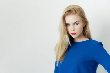 Mavi elbiseli poz yüzündeki kırmızı dudaklı kadın