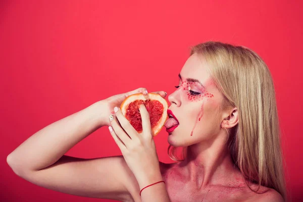 Vrouw met creatieve modieuze make-up greep grapefruit, vitamine — Stockfoto