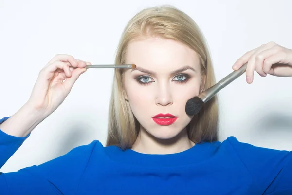 Mujer con cepillos aplicando polvo y maquillaje en la cara — Foto de Stock